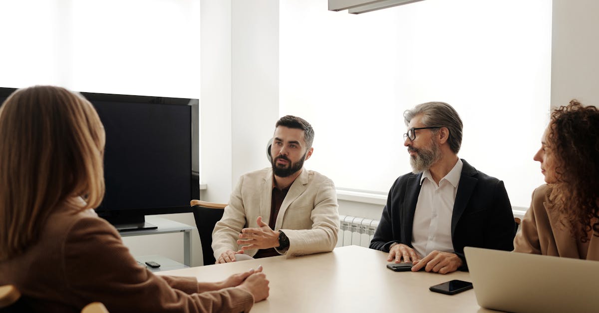 A diverse group of business professionals engaged in a meeting in an office setting.
